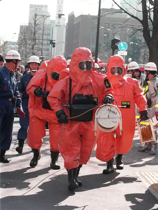 Petugas pemadam kebakaran memeriksa lokasi serangan gas sarin di Tokyo, Jepang, 20 Maret 1995. Anggota sekte kiamat Aum Shinrikyo meninggalkan kantung-kantung berisi racun saraf cair di jalur kereta yang melalui Tokyo. (JIJI PRESS/AFP)