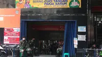 Sejumlah personel TNI berjaga di salah satu pintu masuk Pasar Tanah Abang Blok A. (Liputan6.com/M Radityo Priyasmoro)