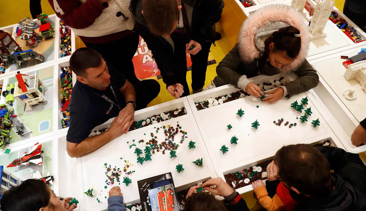 Pengunjung menyusun lego membentuk pohon natal di toko lego terbesar di dunia di Leicester Square, London, Kamis (17/11). Didalam toko lego terbesar di dunia itu banyak memamerkan berbagai benda yang terbuat dari Lego. (REUTERS/Stefan Wermuth)