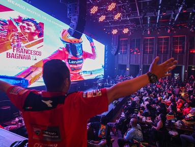 Seorang penonton melakukan selebarasi saat pembalap Ducati Lenovo, Francesco Bagnaia menjadi Juara Dunia MotoGP 2023 ketika acara nonton bareng MotoGP Valencia 2023 bersama Pertamina Enduro di HW Live House, Kemang, Jakarta, Minggu (26/11/2023). (Bola.com/Bagaskara Lazuardi)
