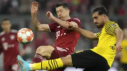 Gelandang Borussia Dortmund Emre Can (kanan) berebut bola dengan penyerang Bayern Munchen Robert Lewandowski pada pekan ke-31 Bundesliga musim 2021/2022 di Allianz Arena, Minggu (24/4/2022) dini hari WIB. Bayern Munchen kembali menjadi juara Bundesliga usai menghajar rivalnya Borussia Dortmund 3-1. (AP Photo/Matthias Schrader)