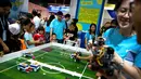 Anak-anak bermain dengan robot-robot kecil dari Roborobo di Konferensi Robot Dunia 2018 di Beijing, China, Rabu (15/8). (AP Photo/Mark Schiefelbein)
