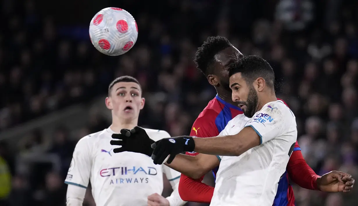 Gelandang Manchester City, Riyad Mahrez berebut bola dengan pemain Crystal Palace, Odsonne Edouard selama pertandingan lanjutan Liga Inggris di Selhurst Park, London, Selasa (15/3/2022). Manchester City bermain imbang atas Crystal Palace 0-0. (AP Photo/Matt Dunham)