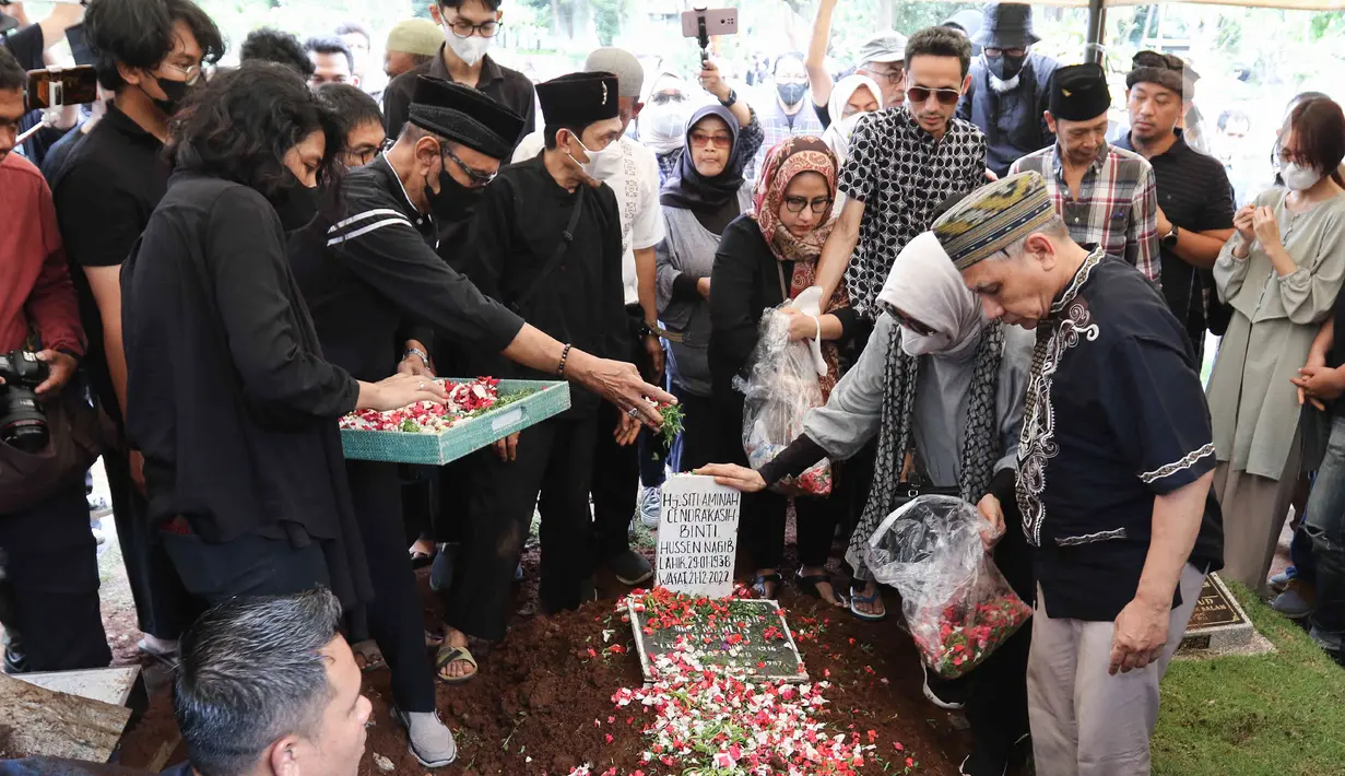 Keluarga dan kerabat melakukan tabur bunga saat prosesi pemakaman aktris senior Aminah Cendrakasih atau Mak Nyak di Taman Pemakaman Umum Karet Bivak, Jakarta, Kamis (22/12/2022). Pemeran Mak Nyak dalam Si Doel Anak Sekolahan meninggal dunia pada 21 Desember 2022 pukul 19.40 WIB karena mengidap penyakit glaukoma yang sudah menahun. (Liputan6.com/Herman Zakharia)