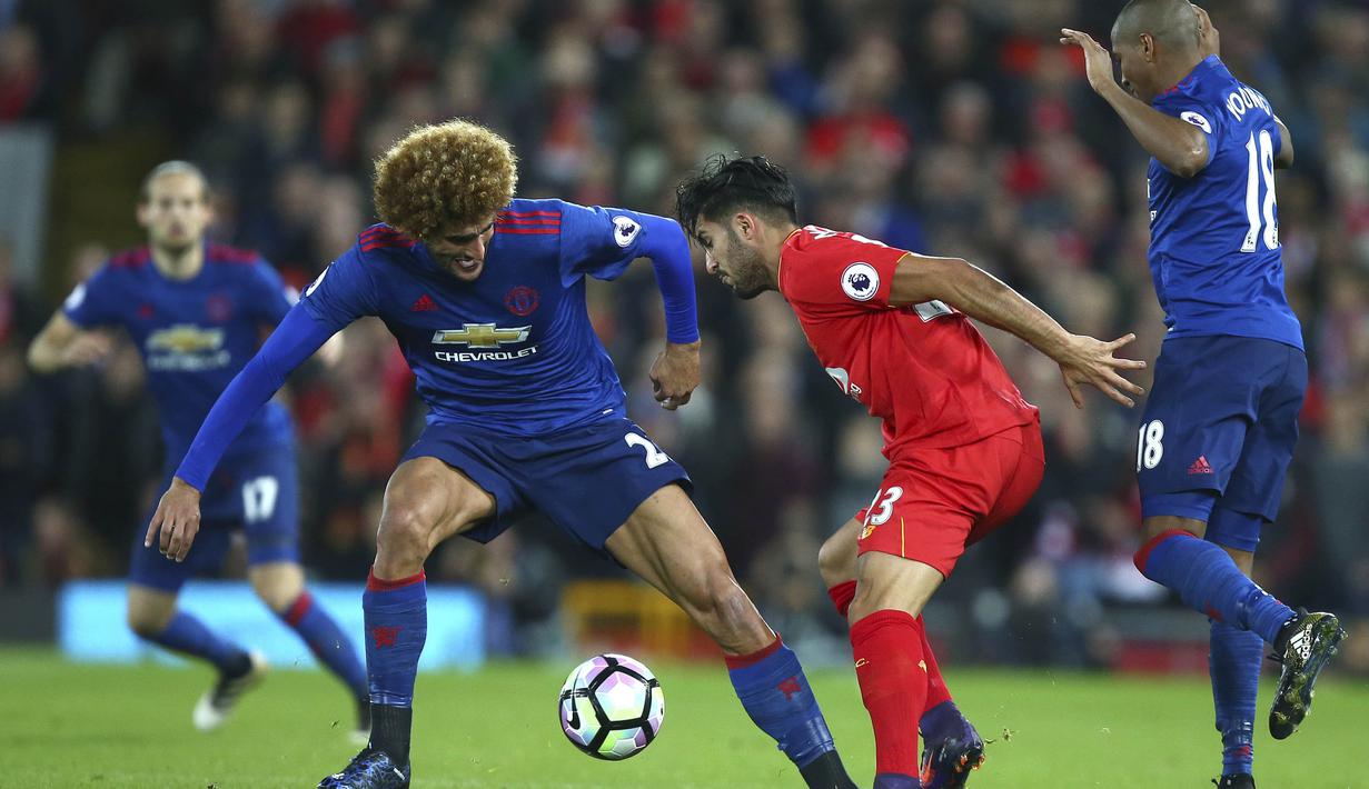 Pemain Liverpool, Emre Can mencoba melewati handangan dua pemain Manchester United pada laga Premier League di Stadion Anfield, Liverpool, Selasa (18/10/2016) dini hari WIB.  (AP/Dave Thompson)