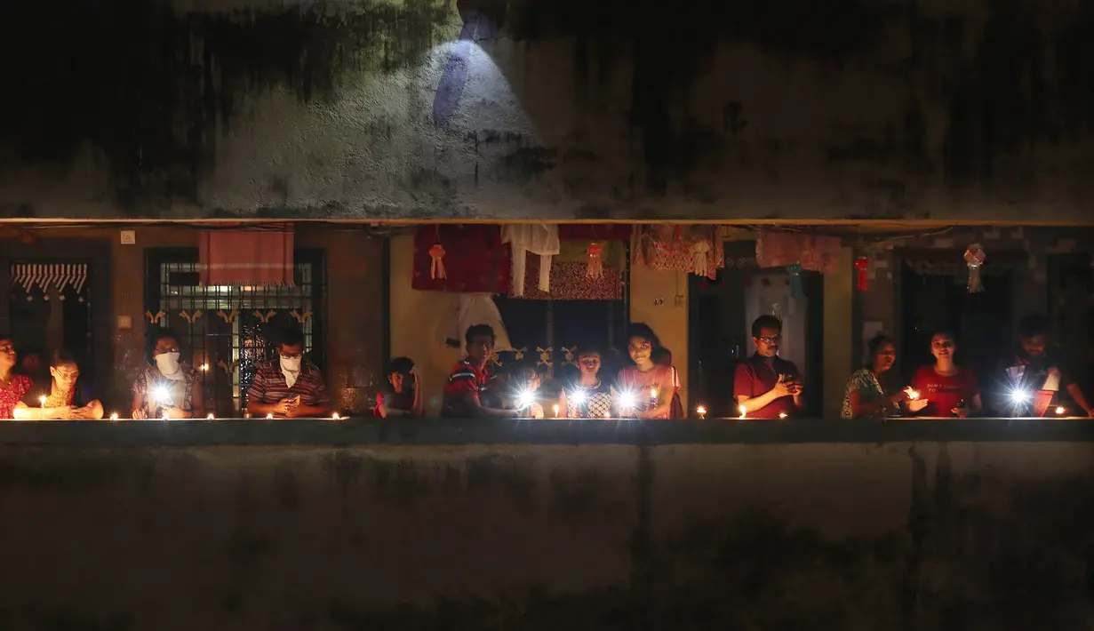 Warga menyalakan lilin dan obor untuk menandai perjuangan melawan pandemi virus corona COVID-19 di Mumbai, India, Minggu (5/4/2020). Perdana Menteri India Narendra Modi mengimbau warga mematikan lampu untuk menunjukkan dukungan mereka terhahap perjuangan melawan COVID-19. (AP Photo/Rafiq Maqbool)