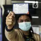 Warga menujukkan Kartu Vaksinasi COVID-19 saat mengikuti vaksinasi gratis di Stasiun MRT, Jakarta, Jumat (23/7/2021). Penyuntikan vaksin COVID-19 dosis pertama tersebut menargetkan 1.800 peserta. (Liputan6.com/Johan Tallo)