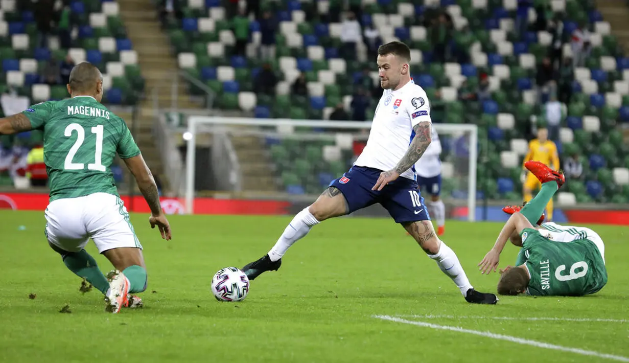 Pemain Slovakia Albert Rusnak (tengah) mencoba melewati pemain Irlandia Utara Josh Magennis pada pertandingan playoff babak semifinal Euro 2020 di Windsor Park, Belfast, Irlandia Utara, Kamis (12/11/2020). Slovakia merebut tiket Euro 2020 usai mengalahkan Irlandia Utara. (AP Photo/Peter Morrison)