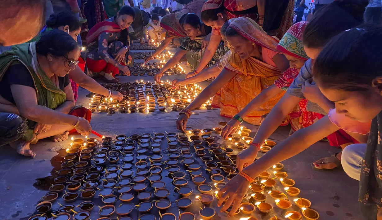 Orang-orang menyalakan lampu di tepi sungai Saryu di Ayodhya, India, Rabu (3/11/2021). Lebih dari 900.000 lampu minyak dinyalakan dan terus menyala selama 45 menit saat kota Ayodhya mempertahankan Rekor Dunia Guinness sebagai bagian dari perayaan festival Diwali. (AP Photo/Rajesh Kumar Singh)