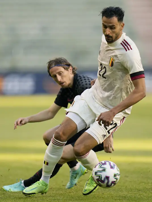 Gelandang timnas Belgia, Nacer Chadli berebut bola dengan gelandang Kroasia, Luka Modric dalam laga uji coba menjelang Euro 2020 di Stade Roi Baudouin, Senin (7/6/2021) dinihari WIB. Menang tipis 1-0, Romelu Lukaku tampil sebagai penentu kemenangan Belgia dengan golnya. (AP Photo/Francisco Seco)