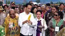 Presiden Joko Widodo dan Ibu Negara, Iriana saat akan mencicipi jagung bakar ketika mengikuti ‎upacara Bakar Batu bersama masyarakat Pegunungan Tengah Papua di Stadion Mini Pendidikan, Distrik Wamena, Kabupaten Jayawijaya‎, Rabu (30/12). (Rumgapres)