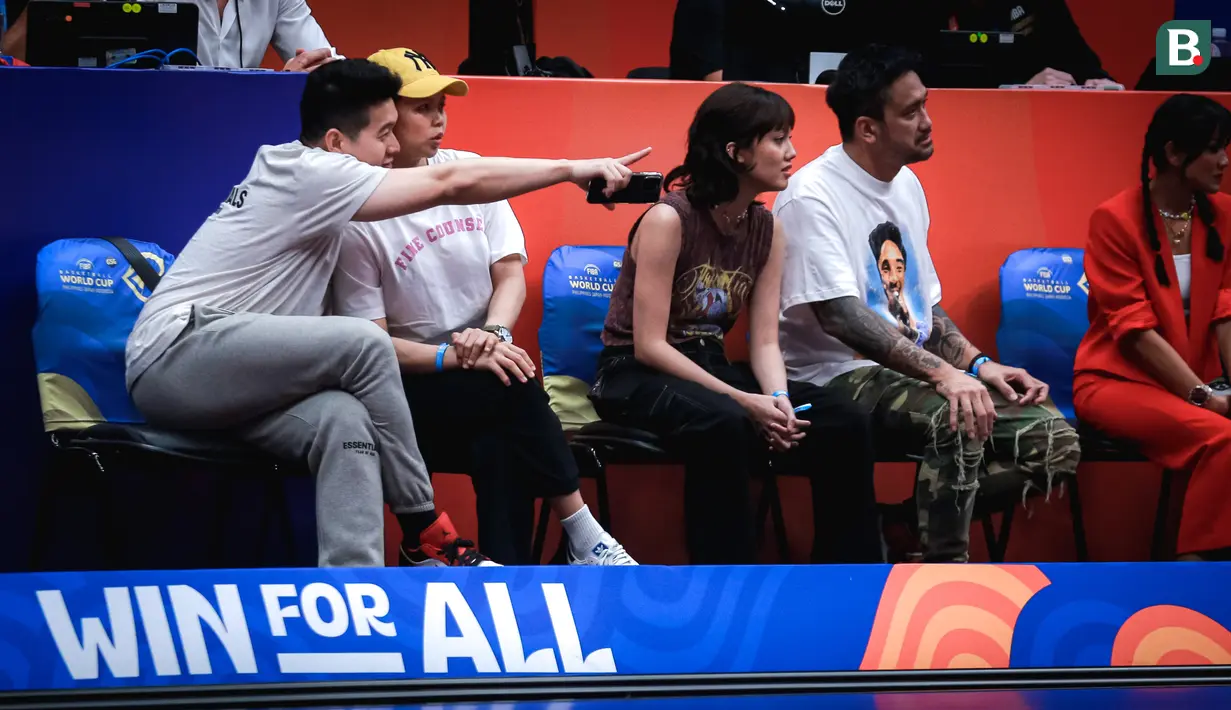 Mantan pebulu tangkis Indonesia, Greysia Polii (tengah kiri) bersama suaminya, Felix Djimin (kiri) duduk di samping selebritas Tora Sudiro (kanan) bersama putrinya, Azzahra Nabila Sudiro saat menyaksikan laga Grup H Piala Dunia FIBA 2023 antara Kanada melawan Prancis di Indonesia Arena, Senayan, Jakarta, Jumat (25/08/2023). (Bola.com/Bagaskara Lazuardi)