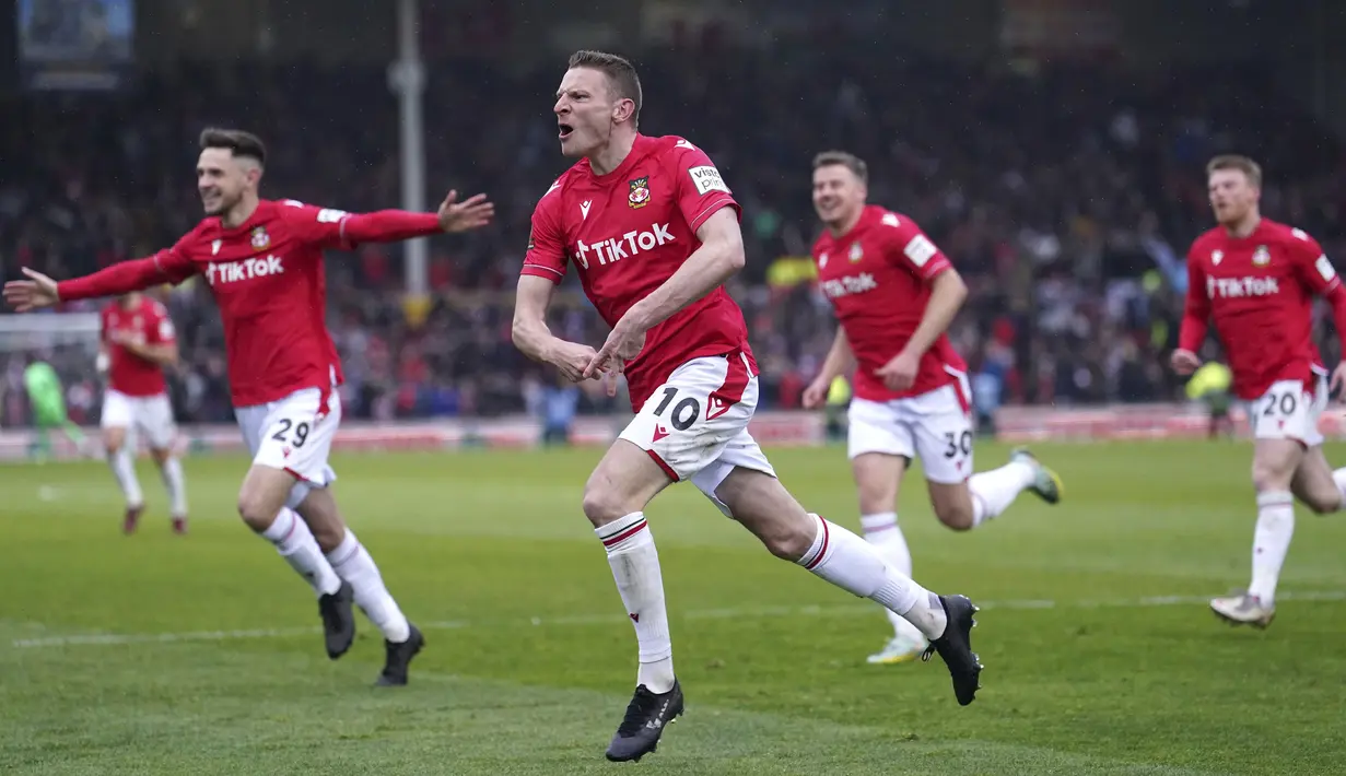 Selebrasi pemain Wrexham, Paul Mullin setelah mencetak gol ke gawang Boreham Wood dalam pertandingan English National League yang berlangsung di The Racecourse Ground, Wales, Sabtu (22/4/2023) WIB. Paul Mullin mencetak brace dalam kemenangan 3-1 yang diraih Wrexham. (AP/PA/Martin Rickett)