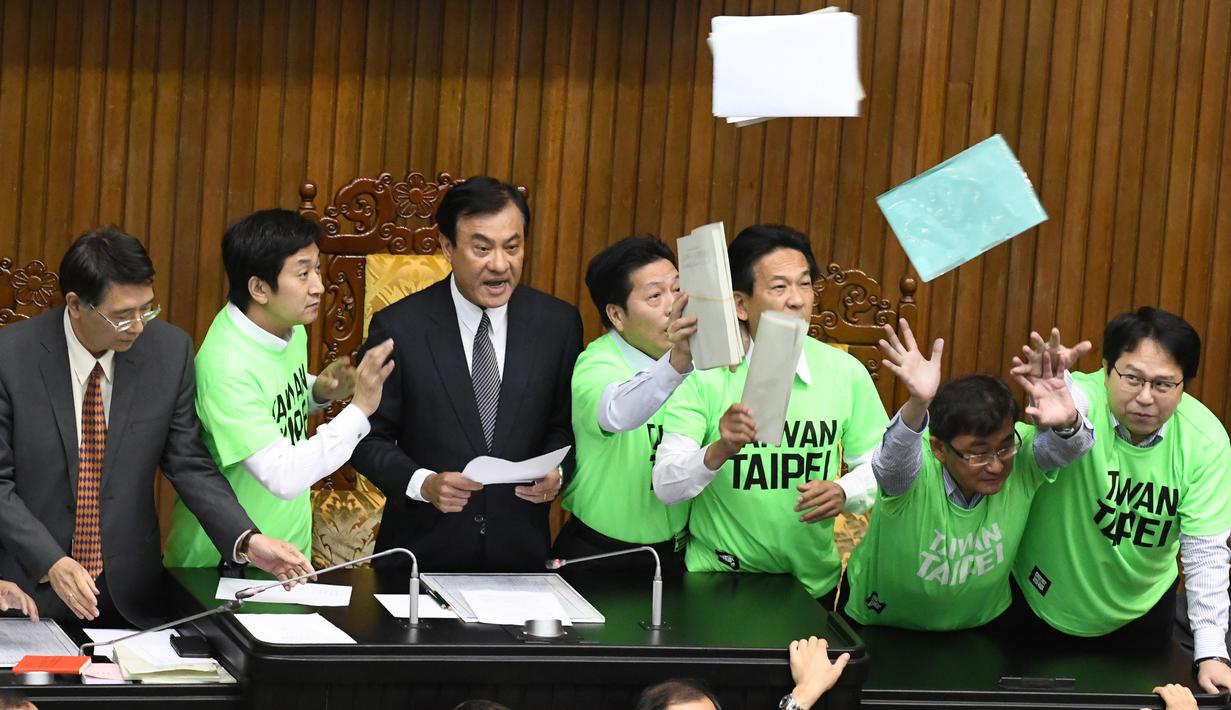 Anggota parlemen dari Partai Progresif Demokratik (DPP) melempar berkas saat melakukan protes di Parlemen di Taipei (20/4). Para legislator tersebut bentrok saat membahas rancangan undang-undang untuk mereformasi sistem pensiun militer.(AFP Photo/Sam Yeh)