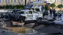 Mobil yang rusak terlihat di lokasi serangan rudal Rusia di Kiev, Ukraina, Senin (10/10/2022). Dua ledakan terdengar di pusat Kiev sekitar pukul 08.00 waktu setempat. (AP Photo/Efrem Lukatsky)