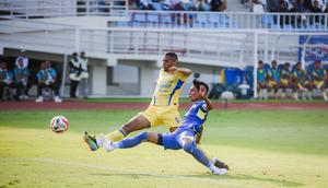 Bek kiri Arema FC, Johan Alfarizi menjuauhkan bola dari kejaran striker Persib Bandung, Uilliam Barros dalam laga pekan keenam BRI Super League 2025/2026 di Stadion Kanjuruhan, Kabupaten Malang, Senin (22/9/2025). (Bola.com/Iwan Setiawan).