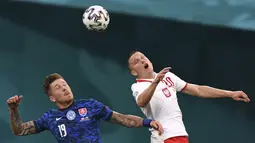 Gelandang Slovakia, Juraj Kucka berebut bola udara dengan pemain Polandia, Piotr Zielinski pada pertandingan grup E Euro 2020 di stadion Saint Petersburg di St. Petersburg, Rusia, Senin (14/6/2021).  Slovakia menang tipis atas Polandia 2-1. (Kirill Kudryavtsev/Pool via AP)