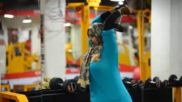 Seorang wanita Muslim India mengangkat beban saat berlatih di gym Ahmedabad Fitness Academy (AFA) di Ahmedabad (10/5/2019). Selama bulan suci Ramadhan, tempat gym ini tetap buka hingga larut malam untuk membiarkan anggota Muslim berolahraga setelah salat. (AFP Photo/Sam Panthaky)