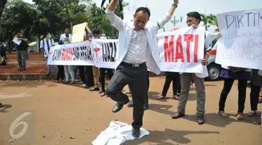Massa menginjak jas putih khas dokter saat melakukan unjuk rasa di depan Istana Merdeka, Jakarta, Senin (7/9/2015). Mereka memprotes Kemenristek Dikti yang telah menahan ijazah fakultas kedokteran mereka. (Liputan6.com/Gempur M Surya)