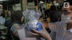 Warga saat membeli masker di Pasar Pramuka, Jakarta, Senin (2/3/2020). Kedua pasien tersebut merupakan ibu (64) dan anak (31), kini mereka dirawat di ruangan khusus serta kediaman yang dihuni pasien di daerah Depok juga diisolasi. (Liputan6.com/Faizal Fanani)