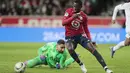 Penyerang Lille Timothy Weah menggiring bola melewati kiper Paris Saint-Germain (PSG) Gianluigi Donnarumma dalam lanjutan Liga Prancis di Stadion Pierre-Mauroy, Senin (7/2/2022) dinihari WIB. PSG mengalahkan juara bertahan Lille dengan skor 5-1. (AP Photo/Michel Spingler)