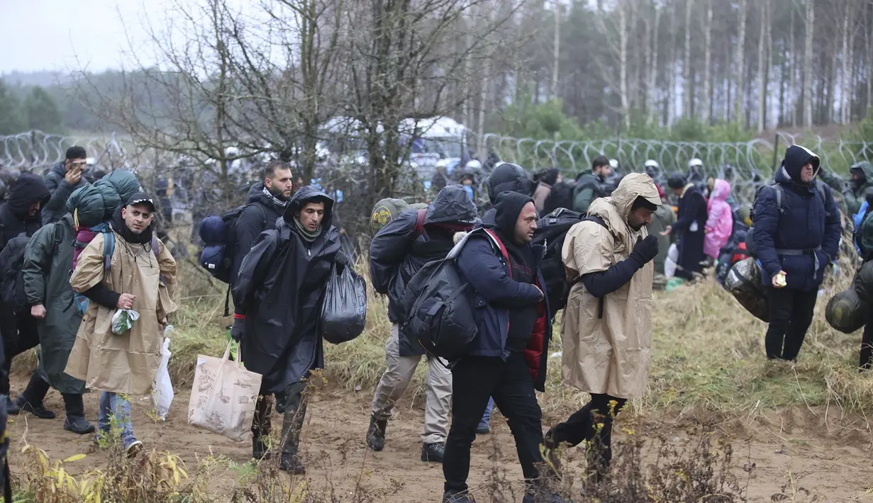 Migran dari Timur Tengah dan tempat lain berkumpul di perbatasan Belarus-Polandia dekat Grodno, Belarus, Senin (8/11/2021). Polandia meningkatkan keamanan di perbatasannya dengan Belarus, di perbatasan timur Uni Eropa. (Leonid Shcheglov/BelTA via AP)