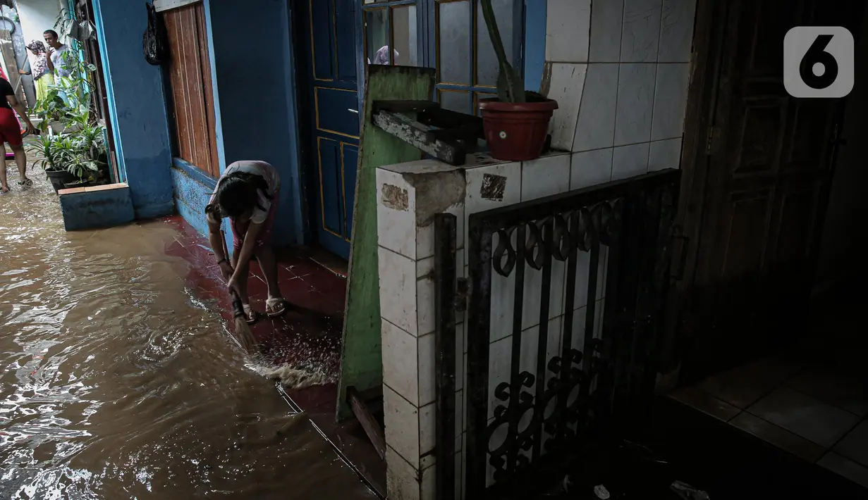 Warga dengan alat seadanya membersihkan rumah yang terendam banjir di kawasan Rawajati, Kalibata, Jakarta, Senin (10/10/2022). Tingginya curah hujan di kawasan Bogor mengakibatkan ratusan rumah di enam RT Kelurahan Rawajati terendam banjir dengan ketinggian mencapai dua meter. (Liputan6.com/Faizal Fanani)
