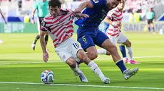 Pemain Amerika Serikat Christian Pulisic menggiring bola sementara pemain Bosnia Sead Kolasinac menarik bajunya selama pertandingan sepak bola babak 32 Piala Dunia antara Amerika Serikat dan Bosnia di Santa Clara, California, dekat San Francisco, Rabu, (01/07/2026). (AP Photo/Julio Cortez)
