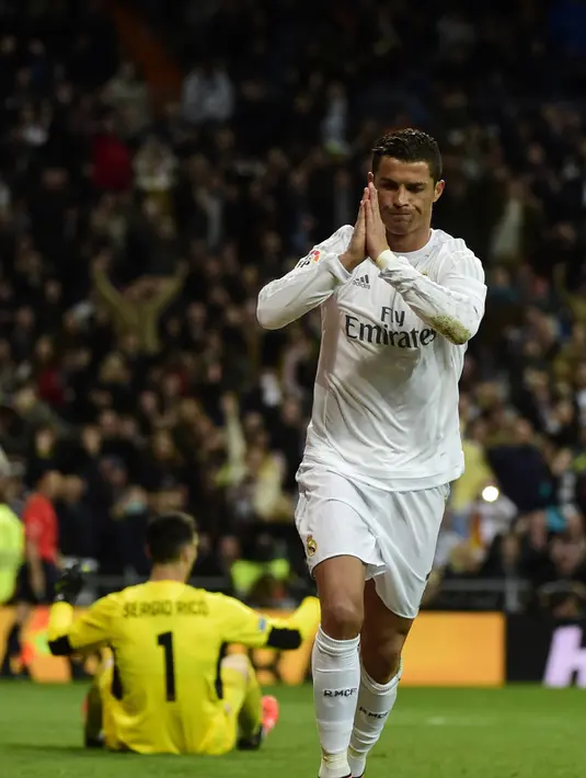 Gelandang Real Madrid, Cristiano Ronaldo melakukan selebrasi usai mencetak gol kegawang Sevilla pada Liga Spanyol di Stadion Santiago Bernabeu (21/3). Real Madrid menang besar atas Sevilla dengan skor 4-0. (AFP/PIERRE-PHILIPPE Marcou)