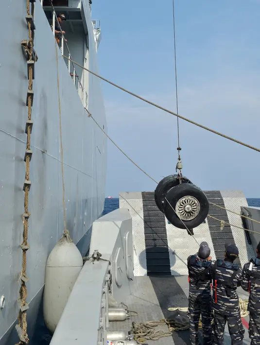 Prajurit TNI AL mengangkat roda pesawat Lion Air PK-LQP dengan nomor penerbangan JT 610 ke atas KRI Banda Aceh selama operasi penyelamatan di perairan Tanjung Karawang, Jawa Barat, Jumat (2/11). (ADEK BERRY/AFP)