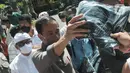 <p>Presiden Joko Widodo membagikan kaos kepada warga saat kunjungan ke Pura Tirta Empul yang terletak di belakang Istana Tampaksiring, Gianyar, Bali, Jumat, (6/5/20222). (merdeka.com/Arie Basuki)</p>