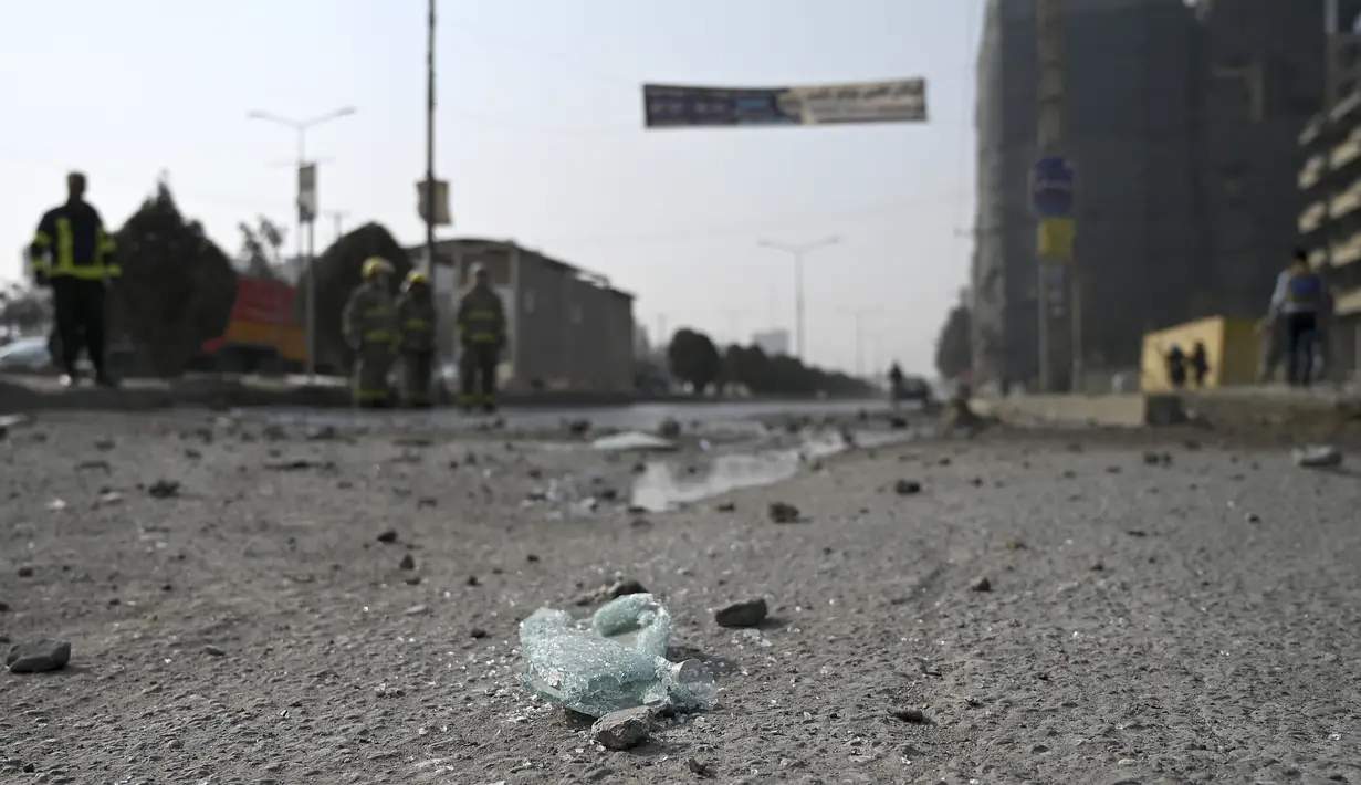 Petugas pemadam kebakaran membersihkan lokasi ledakan bom di Kabul (2/2/2021).  Dua orang tewas ketika ibu kota Afghanistan diguncang serangkaian bom mobil pada jam sibuk, kata para pejabat, sementara seorang polisi kendaraan menjadi sasaran dalam serangan di utara Kabul. (AFP/Bangun Kohsar)