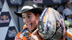 Pembalap dari tim Honda, Marc Marquez berpose sambil memegang helmnya saat merayakan kemenangannya pada MotoGP Amerika di Austin, Texas, (23/4). Valentino Rossi meraih Posisi kedua dan posisi ketiga ditempati Dani Pederosa. (AP Photo/Eric Gay)