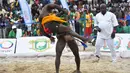 Moussa Faye dari Senegal (kana) bergulat dengan Tambi Nforbong dari Kamerun dalam pertarungan individu 65 kg kategori Final Gulat Wanita Tradisional selama Francophonie ke-8 di Treichville Sports Park di Abidjan pada 29 Juli 2017. (AFP Photo/Sia Kambou)