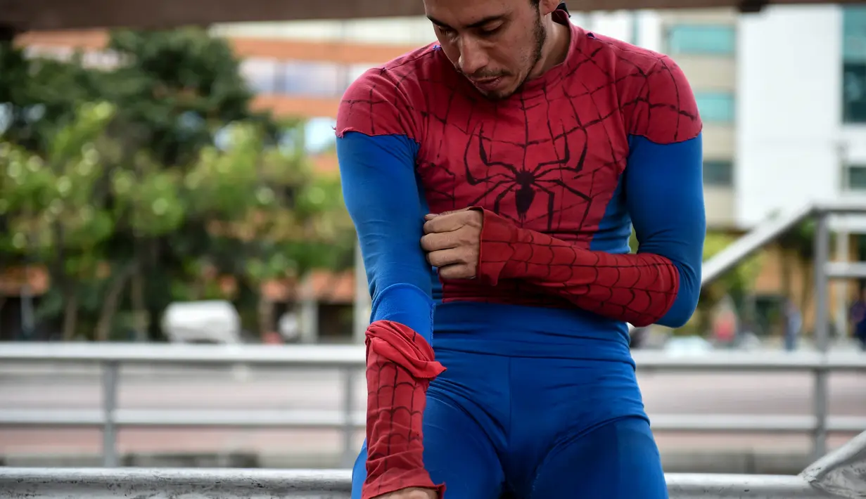 Jahn Fredy Duque mengenakan kostum Spiderman di jalanan Bogota, Kolombia, Senin (24/4). Duque mencari nafkah dengan melakukan atraksi layaknya Spiderman. (AFP Photo/RAUL ARBOLEDA)