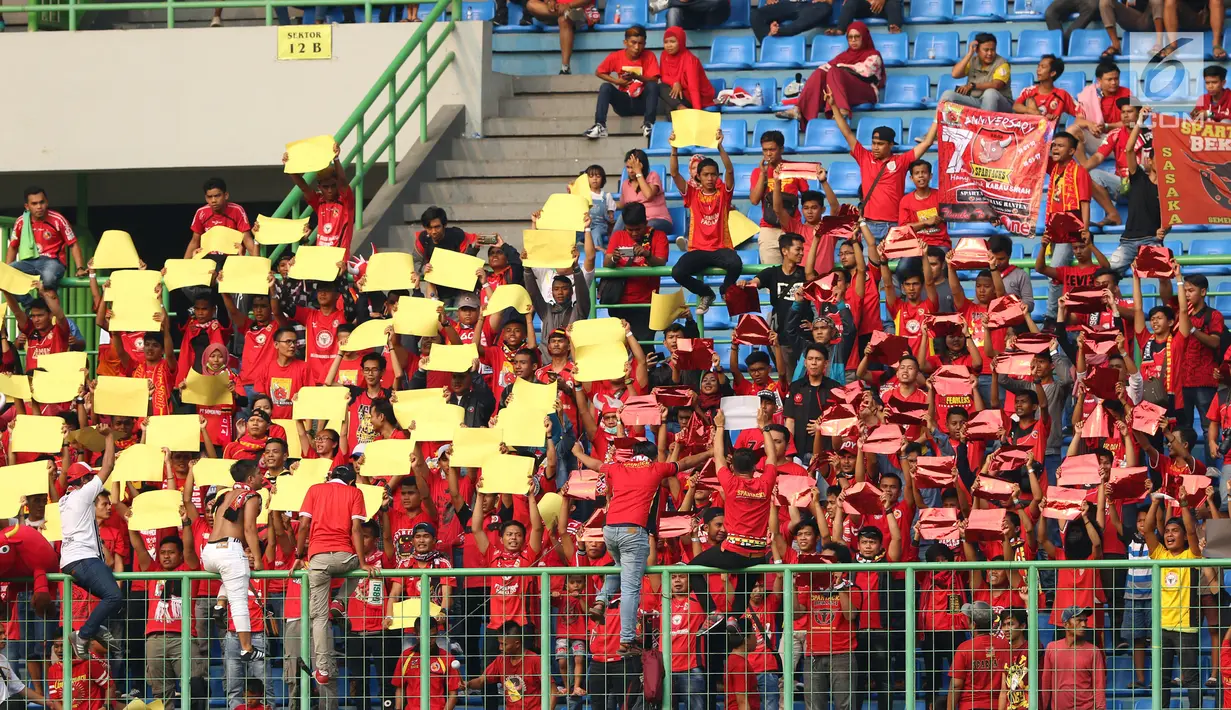 Suporter Semen Padang membuat koreografi saat menyaksikan laga timnya melawan Bhayangkara FC di lanjutan Liga 1 Indonesia di Stadion Patriot Candrabhaga, Bekasi, Sabtu (20/5). Semen Padang kalah 0-1. (Liputan6.com/Helmi Fithriansyah)