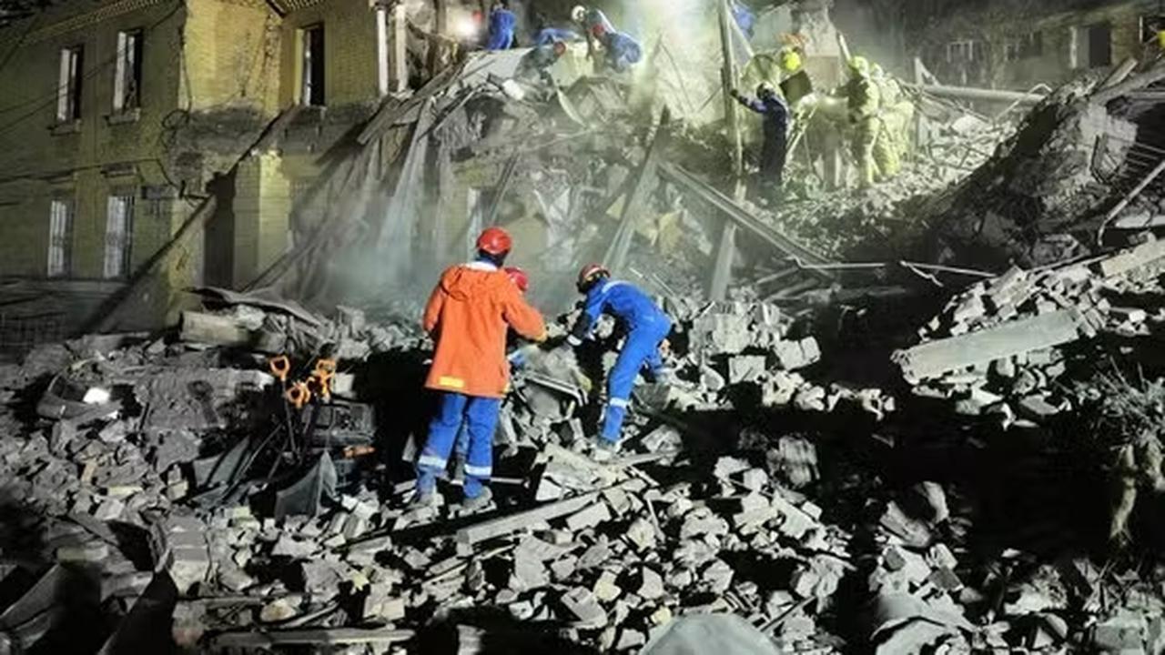 Petugas penyelamat Ukraina membersihkan puing-puing setelah serangan rudal balistik Rusia di Kyiv, Ukraina, Kamis dini hari, 24 April 2025. (EFREM LUKATSKY / AP)