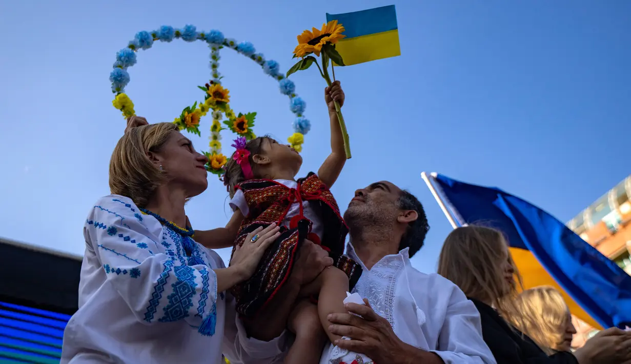 Satu keluarga Ukraina yang tinggal di Chile menghadiri demonstrasi pada peringatan satu tahun invasi Rusia ke Ukraina di Santiago, Chile, 24 Februari 2023. (AP Photo/Esteban Felix)