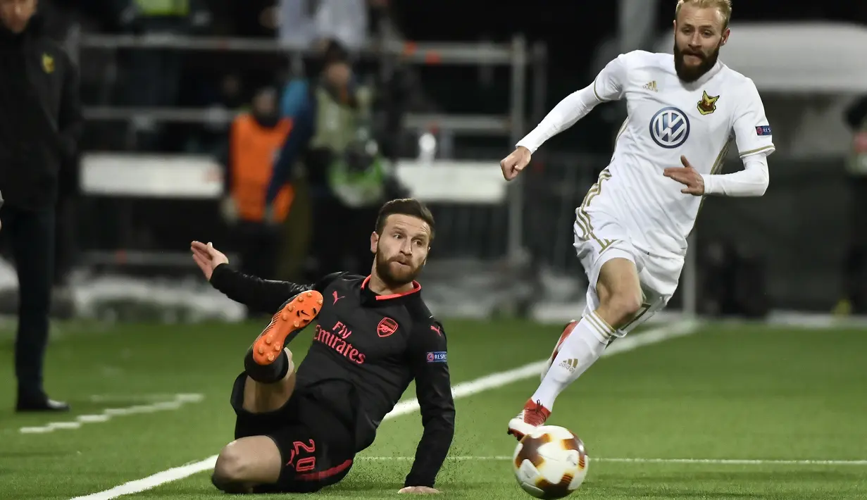 Pemain Arsenal, Shkodran Mustafi (krii) melepaskan umpan saat diadang pemai Ostersund, Curtis Edwards pada babak 32 besar Liga Europa di Jamtkraft Arena, Ostersund, Swedia (15/2/2018). Arsenal menang 3-0. (Robert Henriksson/TT News Agency via AP)