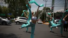 Balerina menampilkan tarian balet saat lampu merah di tengah jalanan Mexico City, 28 Juli 2018. Para balerina dari sanggar Ardentia itu membawakan tarian klasik  untuk menghibur para pengendara di persimpangan yang macet. (AP/Emilio Espejel)
