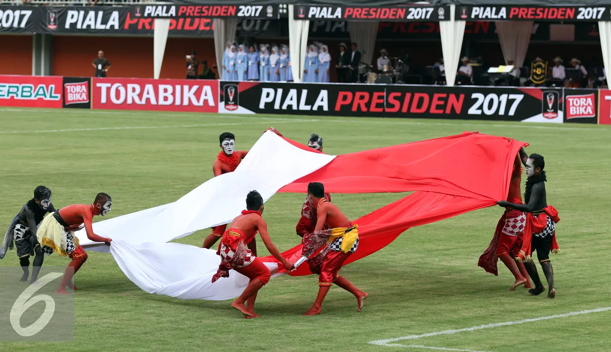 Penari mengangkat kain membentuk bendera Merah Putih saat membawakan tarian kontemporer di Stadion Maguwoharjo, Sleman, Sabtu (4/2). 100 penari D.I. Yogyakarta tampil memeriahkan pembukaan Piala Presiden 2017. (Liputan6.com/Helmi Fithriansyah)