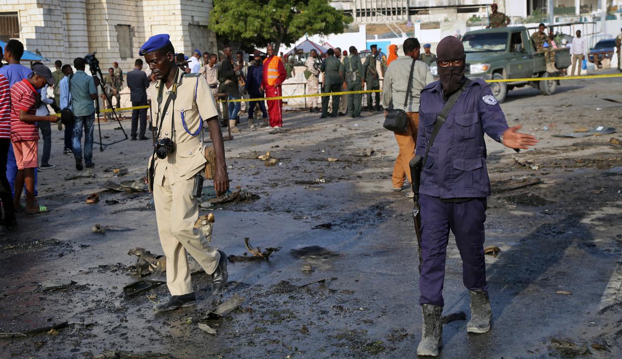 Pasukan keamanan melakukan olah TKP lokasi ledakan bom mobil yang terjadi dekat pos pemeriksaan parlemen dan Kementerian Dalam Negeri di Ibu Kota Somalia, Mogadishu, Minggu (25/3). Tidak ada klaim tanggung jawab atas serangan. (AP/Farah Abdi Warsameh)