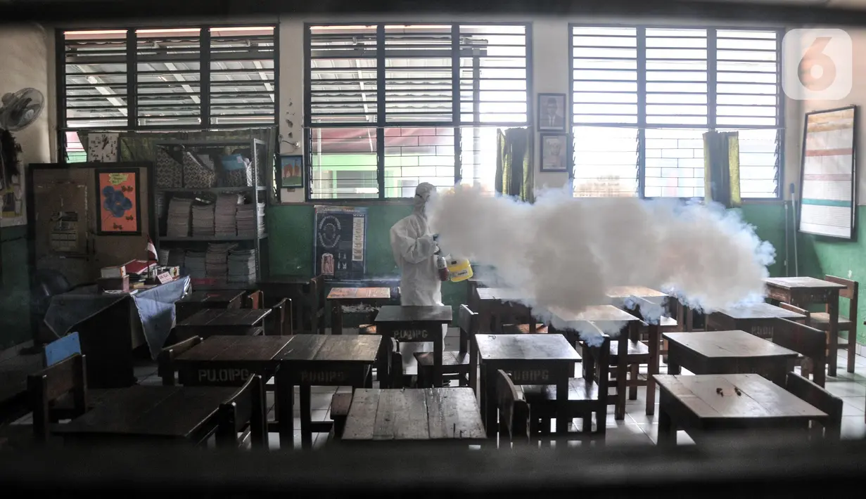 Petugas PMI menyemprotkan disinfektan sebagai upaya pencegahan COVID-19 di SDN Petojo Utara 01, Kecamatan Gambir, Jakarta, Kamis (3/2/2022). Pemerintah melalui Kemendikbud Ristek mengizinkan Pemprov DKI Jakarta menghentikan pelaksanaan PTM 100 persen menjadi 50 persen. (merdeka.com/Iqbal S. Nugroho)