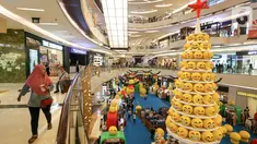 Pengunjung melintas di samping pohon Natal yang didominasi warna kuning setinggi 12 meter di Lippo Mall Kemang,  Jakarta Sabtu (14/12/2019). Pohon dengan konsep Joypixels Emoji momentum liburan menyambut Natal bersama keluarga. (Liputan6.com/Fery Pradolo)