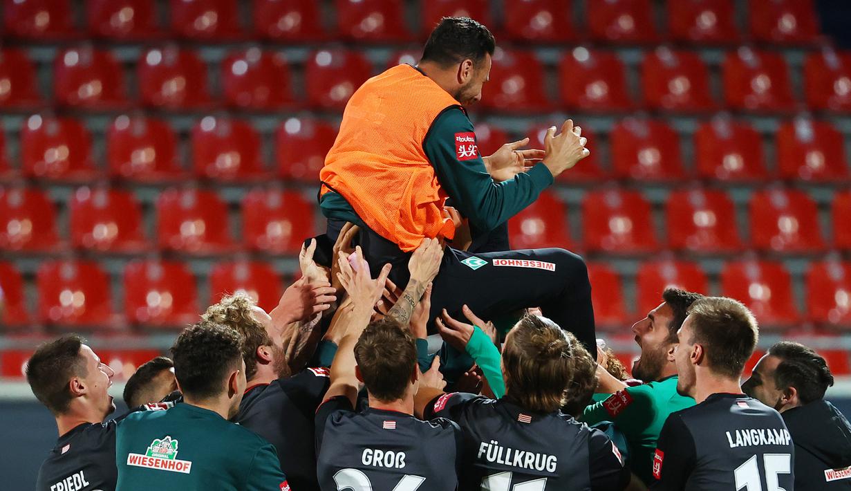 Pemain Werder Bremen merayakan keberhasilan bertahan di kompetisi Bundesliga usai menahan imbang Heidenheim 1846 di laga play-off leg kedua, Selasa (7/7/2020) dini hari WIB. Bremen bermain imbang 2-2 atas Heidenheim. (AFP/Kai Pfaffenbach/pool)