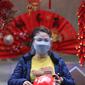 Seorang wanita mengenakan pelindung wajah saat berbelanja di pasar tradisional Tahun Baru Imlek "Tet" di kawasan tua Hanoi, Vietnam, Jumat (28/1/2022). Vietnam merayakan Tahun Baru Imlek yang akan datang di tengah peringatan terhadap perjalanan dan pertemuan besar karena COVID -19. (AP Photo/Hau Din