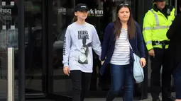 Seorang wanita bernama Amy Trippitt dan putrinya Grace meninggalkan lokasi usai menonton konser Ariana Grande di Manchester, Inggris (23/5). (AP Photo/Danny Lawson)