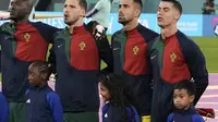 Kapten Timnas Portugal, Cristiano Ronaldo (kanan) bersama Ulul Albab El Ibrahim (kanan bawah), anak asal Indonesia yang mendapatkan kesempatan menjadi player escort di Piala Dunia 2022 saat laga antara Portugal melawan Ghana. (AP Photo/Hassan Ammar)