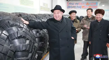Pemimpin Korut, Kim Jong-un saat mengunjungi pabrik ban di Chagang, Korut (3/12). Dalam kunjungannya, Kim Jong-Un mengucapkan terima kasih kepada produsen ban lokal karena telah memproduksi ban untuk kendaraan pengangkut rudal balistik. (KCNA/via AP)