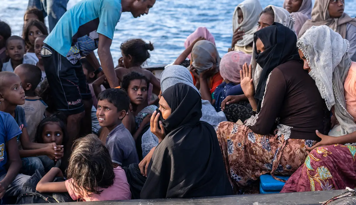 Pengungsi etnis Rohingya berada di atas kapal milik nelayan Indonesia di pesisir Pantai Seunuddon, Aceh Utara (24/6/2020).  Para pengungsi Rohingya diselamatkan nelayan Aceh setelah kapal yang ditumpangi puluhan pengungsi itu rusak. (AP Photo/Zik Maulana)